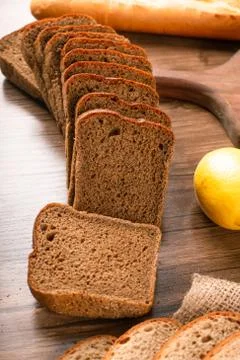 Brown bread with lemons on tablecloth Stock Photos