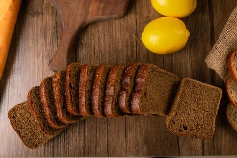 Brown bread with lemons on tablecloth Stock Photos
