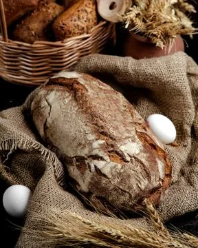 Brown bread loaf served on linen cloth in rustic style Stock Photos