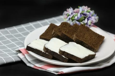 Brown bread with processed cheese on a plate,towels isolated on black background Stock Photos