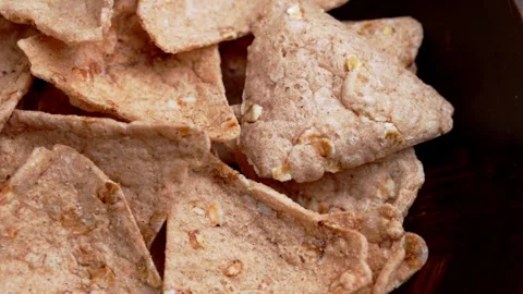 Brown buckwheat nachos with grainy surface in wooden bowl Stock Footage 333104392
