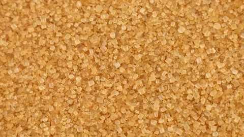 Brown cane sugar crystals circle rotation close up top view Video stock 274907742
