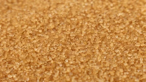 Brown cane sugar crystals falling down close up Stock Footage 274437426