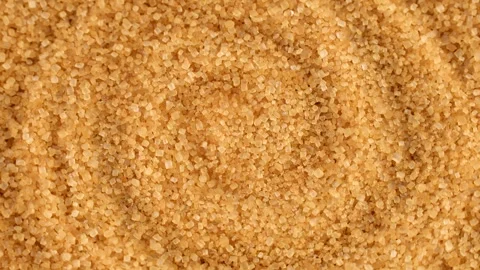 Brown cane sugar crystals texture circle rotation close up top view Stock Footage 276382152