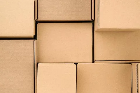 Brown cardboard boxes stacked as full frame packaging background, kraft paper Stock Photos