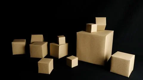 Brown cardboard boxes in various sizes on black background Stock Photos