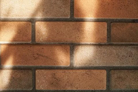 Brown Ceramic Brick Wall Texture with Soft Sunlight and Shadows 스톡 사진