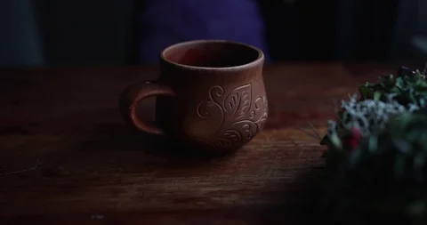 Brown ceramic cup with handle with pattern on wooden table Stock Footage 129709491