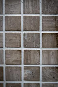 Brown ceramic mosaic on the wall as background Stock Photos