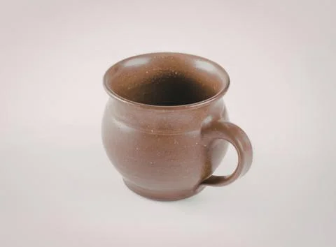 Brown ceramic mug with handle on plain background Photos
