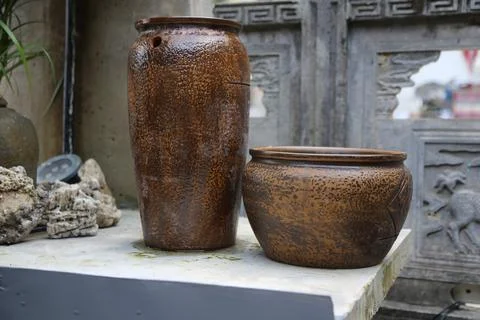 A brown ceramic water jar with texture and roughness is placed on the table. Stock Photos