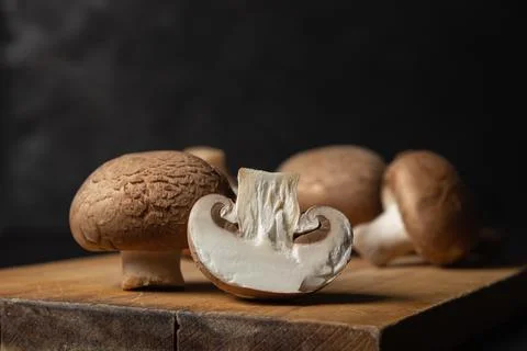 Brown champignons on a black background.  Stock Photos