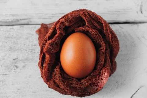 Brown chicken egg inside decorative nest on table. View from above. 스톡 사진