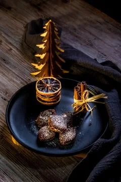 Brown chocolate sweets stuffed by cream on black plate with cinnamon Stock Photos