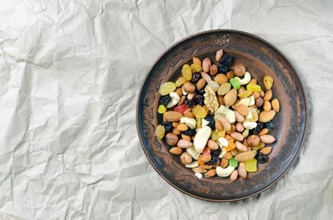 Brown clay plate assorted nuts on vintage paper Stock Photos