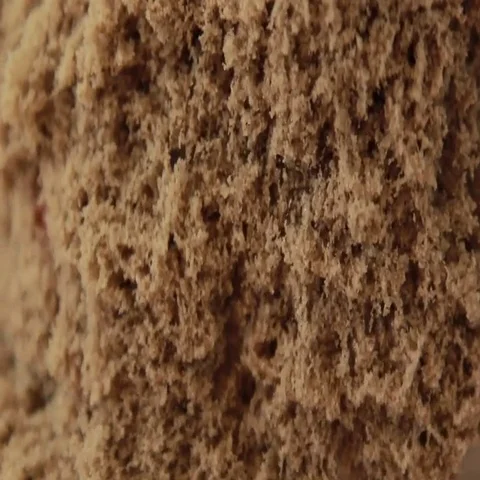 Brown colored kinetic sand quickly falls from female hands, close up Vídeo Stock 69461210