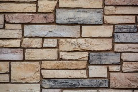 Brown colored stone setting. Cut stone wall texture. Stock Photos