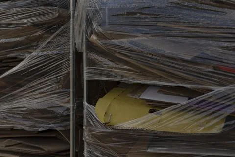 Brown corrugated cardboard secured with ties in warehouse setting Stock Photos
