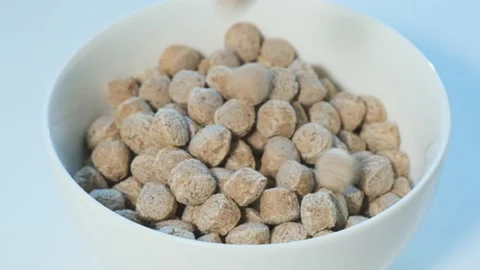 Brown crispy bran balls fall from above into white bowl on light background. Stock-Footage 196268884