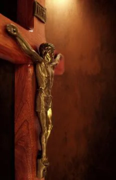 Brown Crucifix with soft light shining down Stock Photos