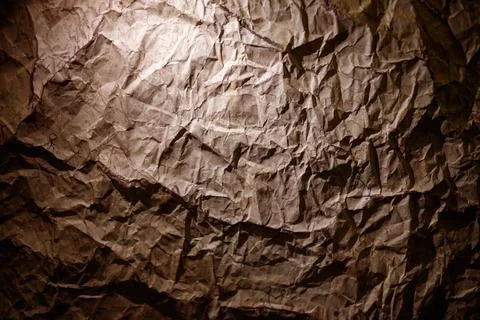Brown crumpled paper background with dramatic lighting and tactile surface Stock Photos