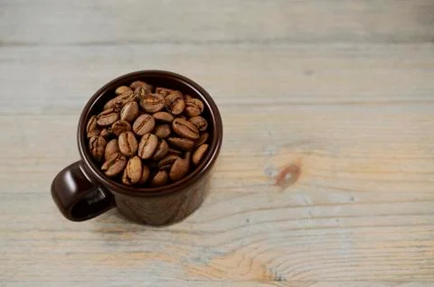 Brown cup with coffee beans Stock Photos
