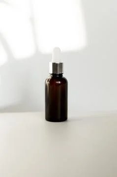 Brown dropper bottle without label on white background with natural light Stock Photos