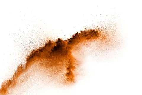 Brown dust exploding cloud.Brown particles splattered on white background. Stock Photos