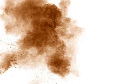 Brown dust explosion cloud.Brown particles splatter on white background. Stock Photos