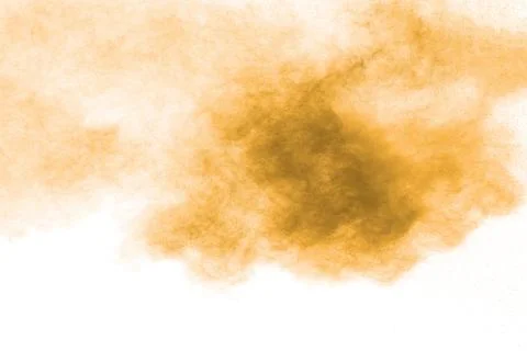Brown dust explosion cloud.Brown particles splatter on white background. Stock Photos