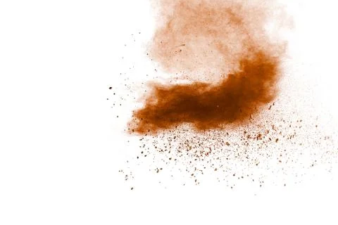 Brown dust splashing.Brown particles splattered on white background. Stock Photos