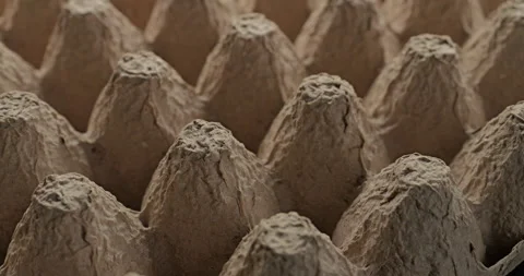 Brown egg carton cardboard with repeating peaks and porous texture in closeup Stock Footage 345030075