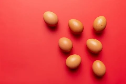 Brown eggs on red background Stock Photos