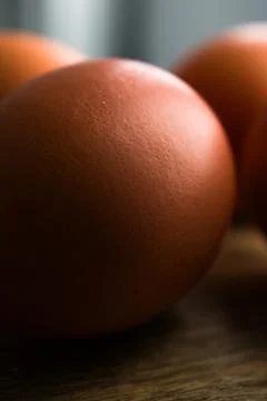 Brown Eggs on Wooden Surface in Dramatic Low-Key Lighting Stock-Fotos