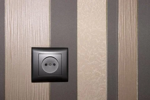 Brown electric socket on an interior wall in brown tones. copy space. Stock Photos