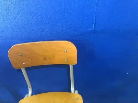 Brown empty school chairs with blue wall on background Foto stock