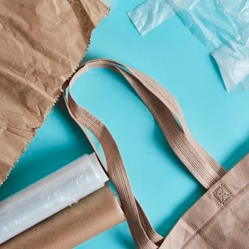 Brown empty Tote Bag next to eco unfriendly pouches and wrap Foto stock