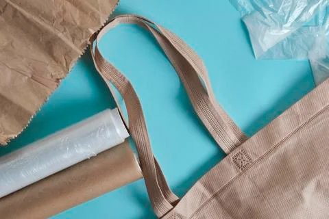 Brown empty Tote Bag next to eco unfriendly pouches and wrap Stock Photos