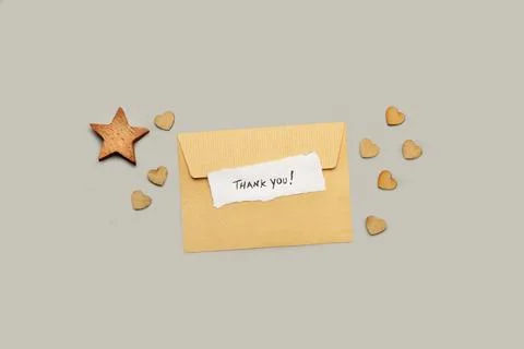 A brown envelope with a thank you note and a wooden star and hearts Stock Photos