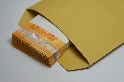 Brown envelope with thick stack of fifty euro banknotes showing Stockfoto's
