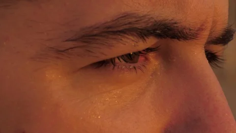 Brown eyed guy face looking at setting sun extreme closeup Stock Footage 124023967