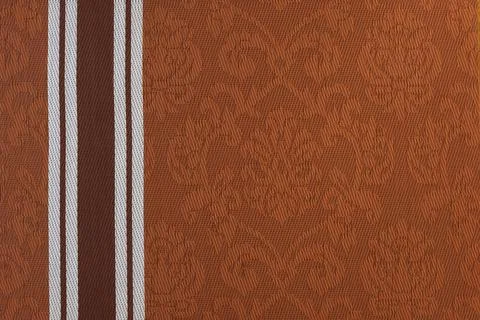 Brown fabric background with a monogram pattern. Stock Photos