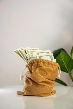 A brown fabric bag with a drawstring closure sits on a white surface. The b.. Stock Photos