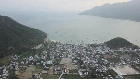 Brown fields and buildings located between sea and hills in Khanh Hoa Vietnam Stock Footage 157248116