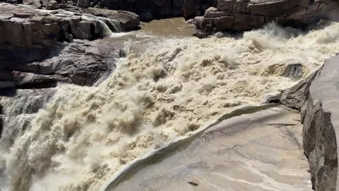 Brown flood waters cascading down Augrabies waterfall Stock Footage 313733042