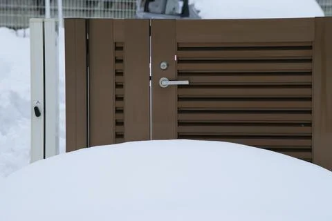 A brown gate with snow in front of it Stock Photos