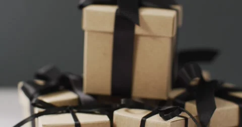 Brown gift boxes with black ribbons on dark grey background Stock Footage 336657840