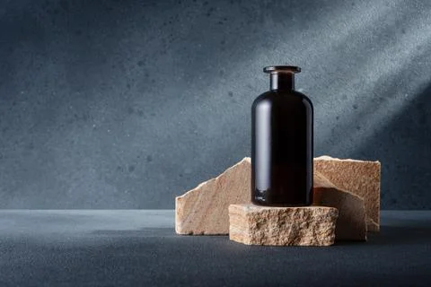 Brown glass bottle for aroma diffuser or other on the stone podium for mock-u Stock Photos