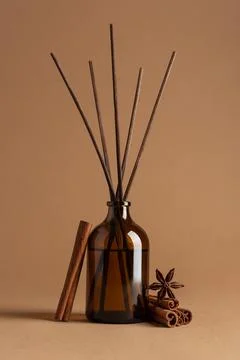 Brown glass reed diffuser with aromatic sticks, cinnamon rolls and star anise Stock Photos