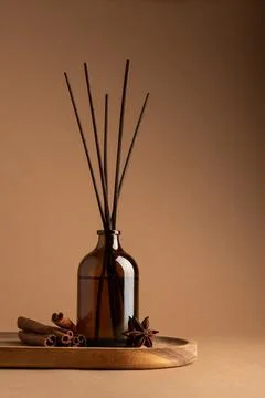 Brown glass reed diffuser with aromatic sticks, cinnamon rolls and star anise Stock Photos